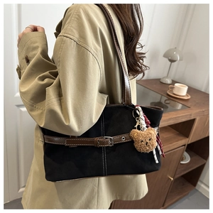 Retro black tote bag with brown leather straps and plush bear pendant shown on model