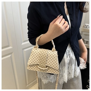On-body view of cream monogram small crossbody bag with geometric circular pattern