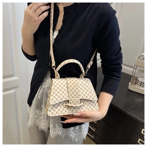 Detail of vintage monogram crossbody bag with flap closure and adjustable strap on a model