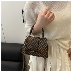 Detail of vintage monogram crossbody bag with flap closure and adjustable gold strap