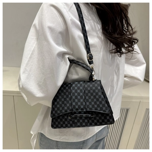 Detailed side view of the geometric patterned crossbody bag with gold buckle hardware