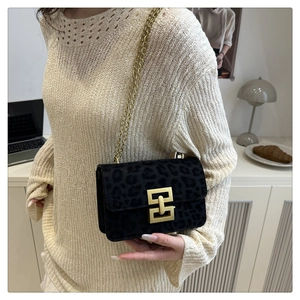 Detail of vintage leopard print crossbody bag with gold metal chain and buckle