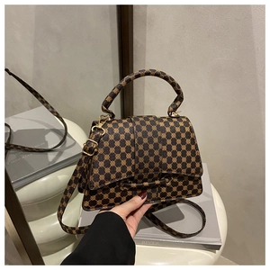 Detail of vintage monogram canvas crossbody bag with gold hardware and curved handle
