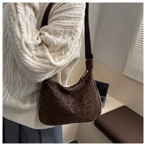 Close-up of brown leopard print hobo bag with a soft suede texture and wide strap