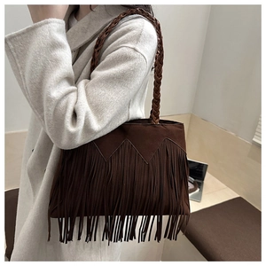 Dettaglio della borsa tote in pelle scamosciata marrone con frange e tracolla intrecciata