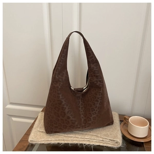 Detail of leopard print tote bag with matte texture on soft brown suede scarf background