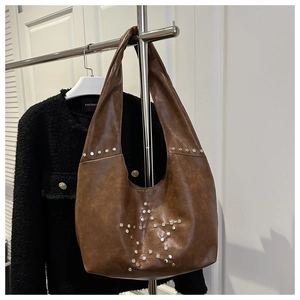 Dettaglio della borsa hobo marrone vintage con borchie argentate a forma di stella
