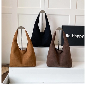 Three minimalist matte hobo tote bags in brown, black, and coffee displayed on metal stands