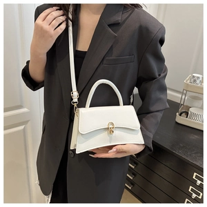 White hourglass-shaped crossbody bag with gold lock shown on model with black suit