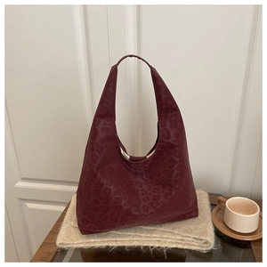 Close-up of deep burgundy leopard print texture on a large capacity leather tote bag