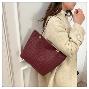 Detail view of large leopard print tote bag with gold chain and leather shoulder strap