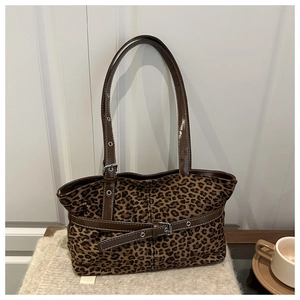 Close-up of leopard print tote bag texture with brown leather strap and metal buckle detail