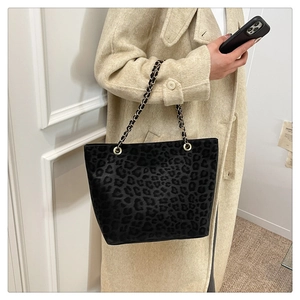 Detail of leopard print tote bag with gold chain strap on beige wool coat