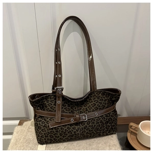 Close-up of leopard print tote bag with brown leather straps and silver buckle detail