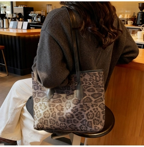 Detailed back view of large leopard print tote bag with black leather straps