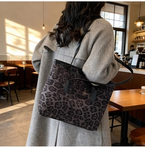 Detailed side view of the leopard print tote bag with black strap and fabric texture