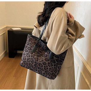 Fashionable leopard print tote bag shown on model in a modern minimalist interior room