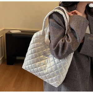 Detailansicht der weißen gesteppten Puffer-Tasche mit schwarzem Mode-Instinkt-Etikett