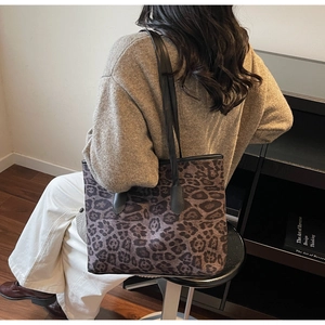 Detail shot of leopard print tote bag styled with a brown knit sweater and light pants