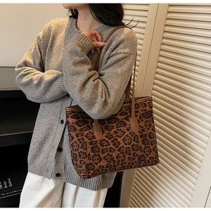 Detail of leopard print tote bag showing reinforced leather strap attachments and finish