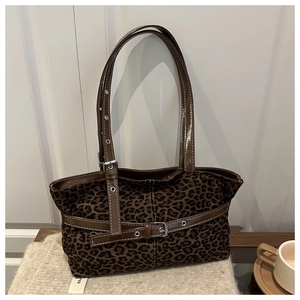 Detail of leopard print tote bag with brown faux leather trim and metallic buckle