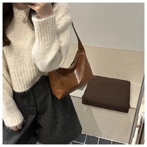 Deep brown matte oil wax leather hobo bag worn with cream knit sweater and grey shorts