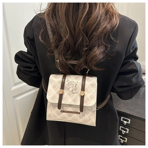 Détail d'un sac à dos vintage à carreaux avec sangles en cuir et boucle magnétique