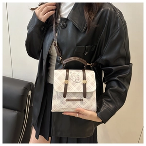 Détail du sac à carreaux avec imprimé ours mignon et accents en cuir marron