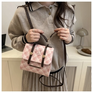 Détail du sac à carreaux rose avec illustration d'ours et lanières en cuir élégantes