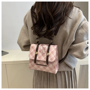 Détail du mini sac à dos à carreaux roses avec motif ours mignon et bretelles en cuir marron