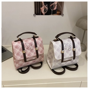Detail of pink and grey checkered PU leather backpacks with cartoon puppy illustrations
