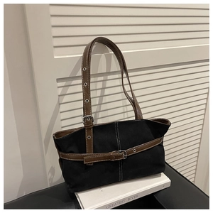 Dettaglio delle cuciture a contrasto e fibbia in pelle di una borsa a spalla in tela
