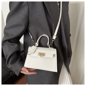 Detailweergave van een witte lederen crossbodytas met gouden slot en riempje
