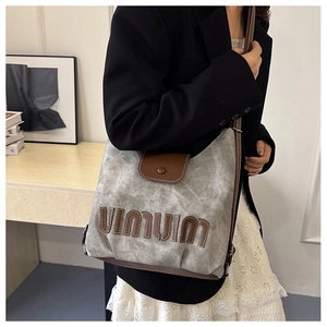 Detail of grey tote backpack with brown leather trim and VIIVIU embroidered patch