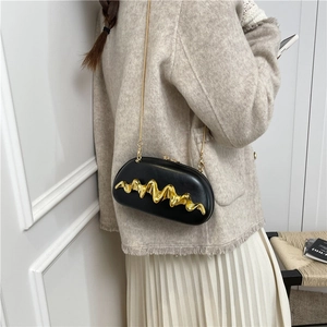Black half-moon clutch bag with golden wave metal trim and slim gold chain strap