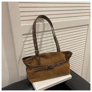 Dettaglio di una grande borsa tote marrone vintage con texture scamosciata e fibbie in pelle