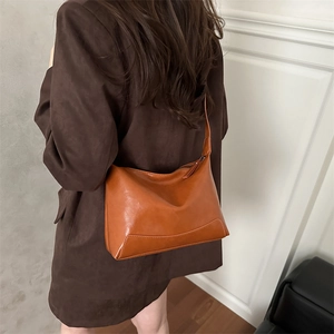 Vintage caramel faux leather tote bag shown on model with minimalist business attire