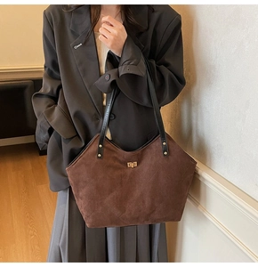 Close-up of the dark brown suede tote bag with diamond stitching and golden square lock