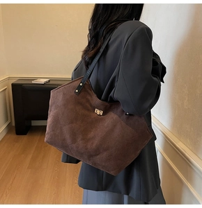 Detail of vintage quilted tote bag in dark brown suede with elegant gold twist lock closure