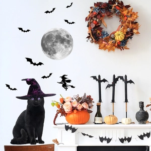 Leuchtende Mond- und Fledermaus-Wandaufkleber an weißer Wand mit Halloween-Deko