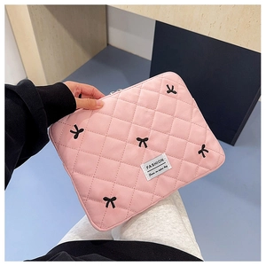 Funda rosa acolchada para portátil con bordados de lazos negros y etiqueta de moda