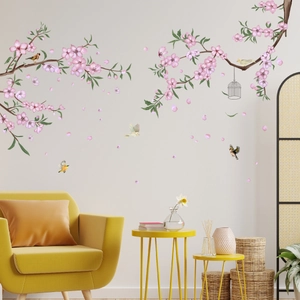 Vinilo decorativo de ramas con flores rosas y aves en una sala de estar moderna