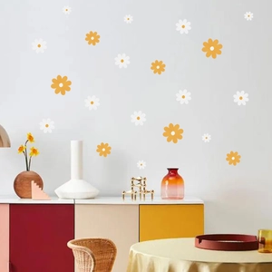 Detail view of white and ginger daisy wall stickers arranged on a clean white bedroom wall
