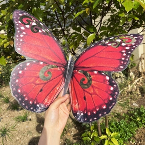Vista detallada de mariposa 3D grande roja decorativa con patrones de alas caladas