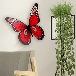 Vista detallada de un adhesivo de pared mariposa roja 3D con patrones plateados y bordes negros