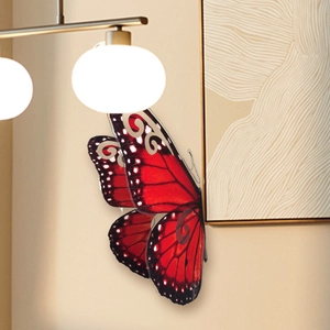 Detalle de mariposa 3D roja de 40 cm con patrones realistas en una pared beige