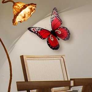 Detalle decorativo de mariposa 3D roja y negra con patrones de espirales y puntos blancos