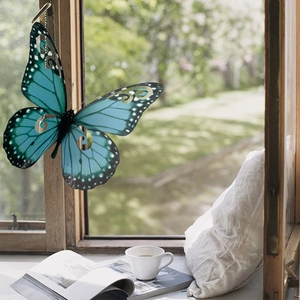 Decoración de mariposa 3D azul en alféizar de ventana de madera con una taza