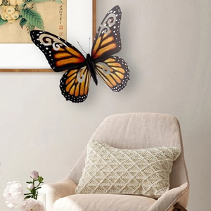 Decoración de pared mariposa 3D naranja con detalles plateados calados en ambiente hogar