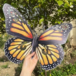 Detalle macro de un adhesivo de pared de mariposa 3D de 40 cm con alas caladas naranjas